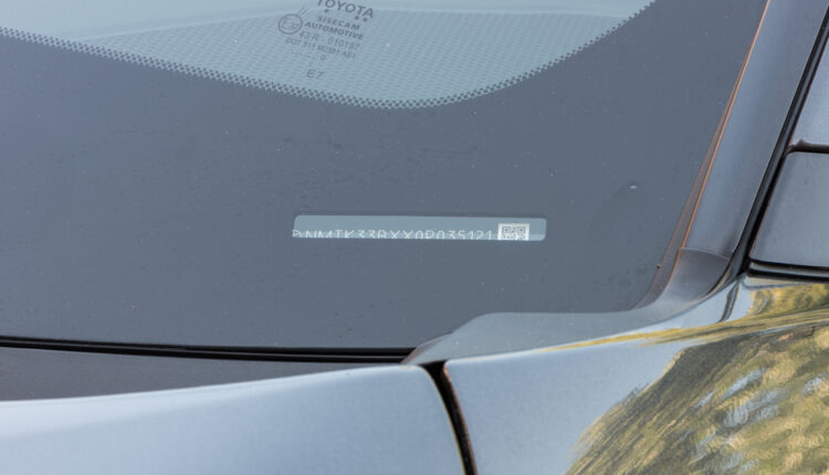 VIN number visible on a car’s dashboard through the windshield, highlighted for identification