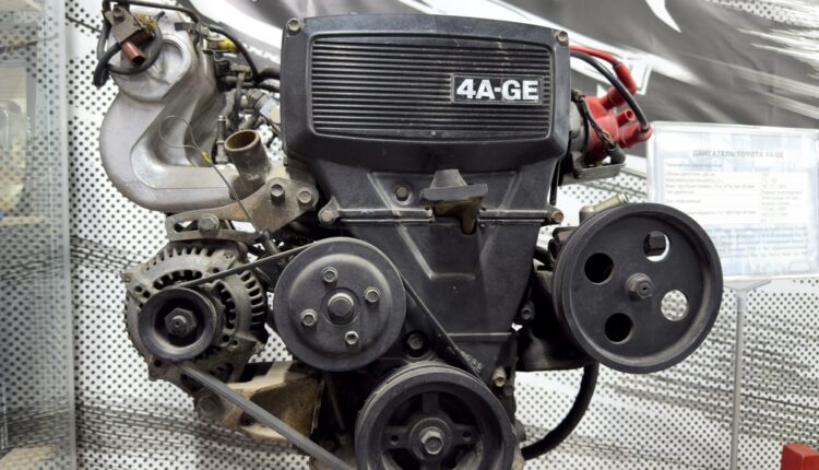 Detailed view of a four-cylinder engine layout with visible belts and components