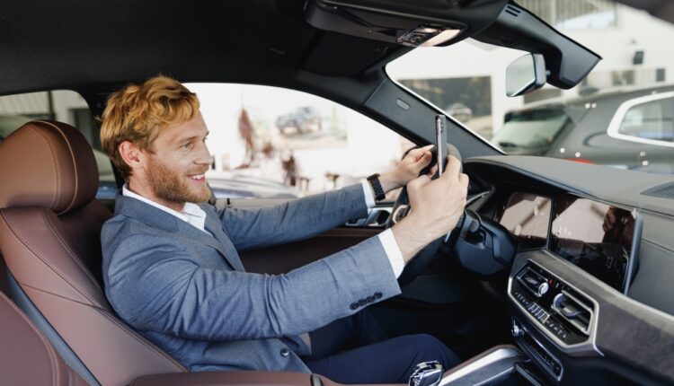 Driver in the UAE reviewing cheapest car insurance quotes on a smartphone