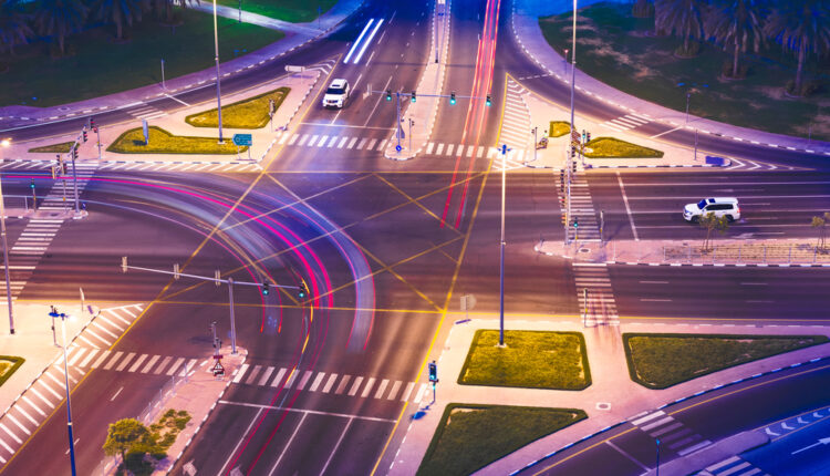 Car using turn signal on UAE road with visible traffic signs