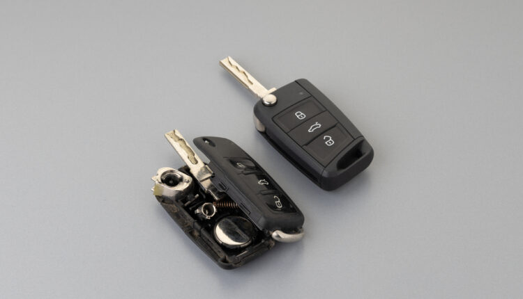 Hand opening a car remote control key to change the battery