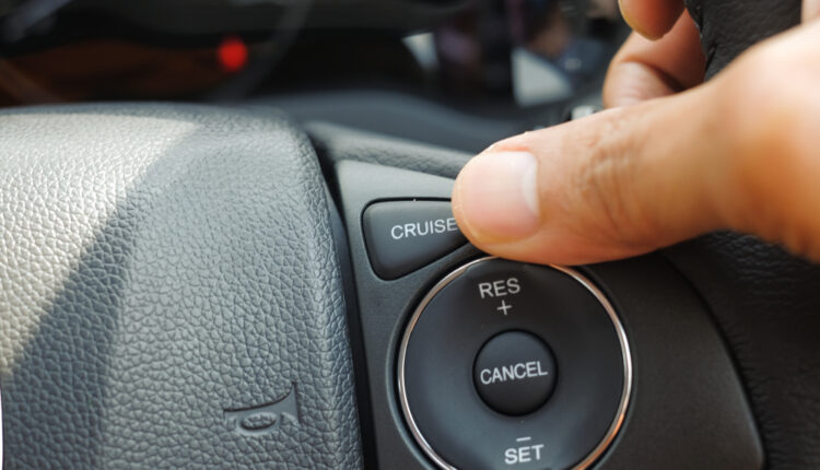 Cruise control button on a car steering wheel, symbolizing automated speed control feature.