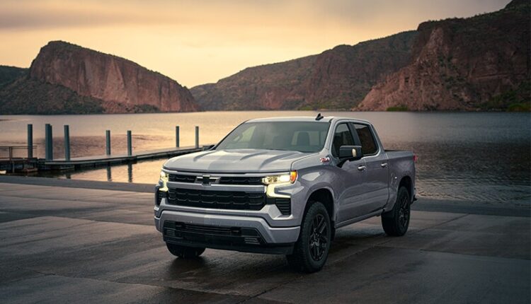 Silver Chevrolet Silverado 1500 crew cab truck parked in front of mountain landscape