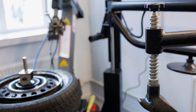 Tire mounted on rotation machine during vehicle service