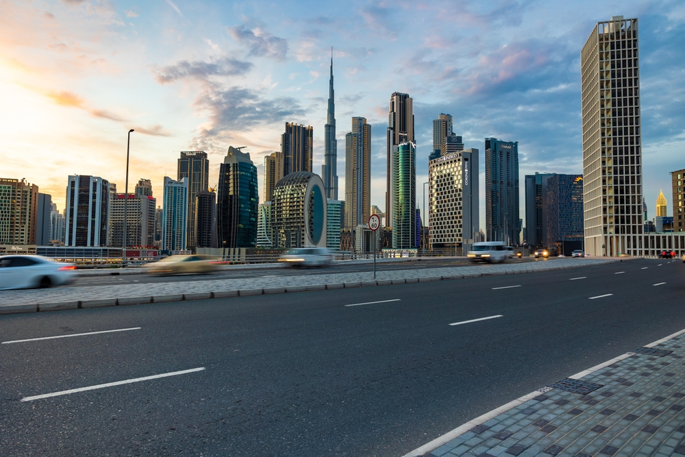 Electric car driving in Dubai showcasing eco-friendly transport