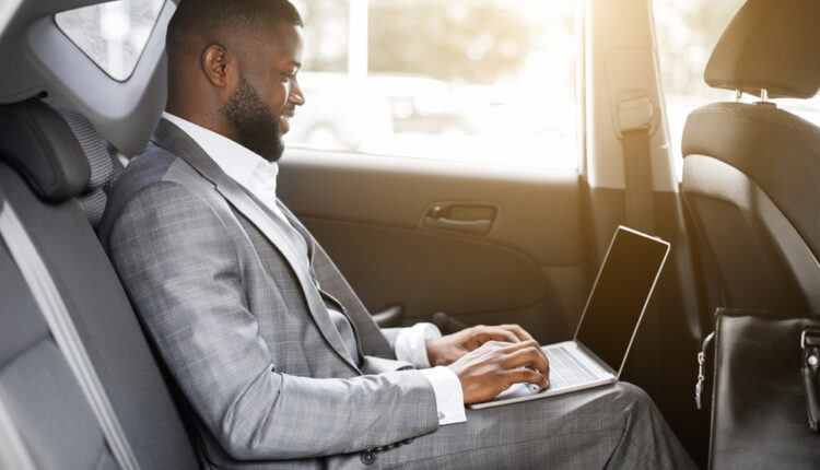 Person checking used car prices online on a laptop for market research