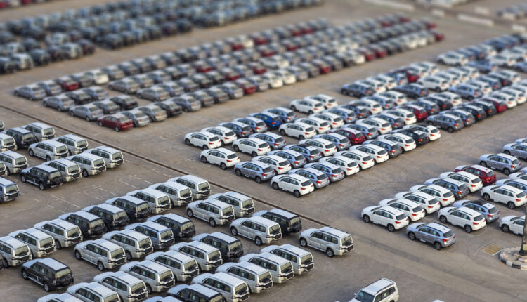 Used car with “For Sale” sign parked against Dubai city skyline.