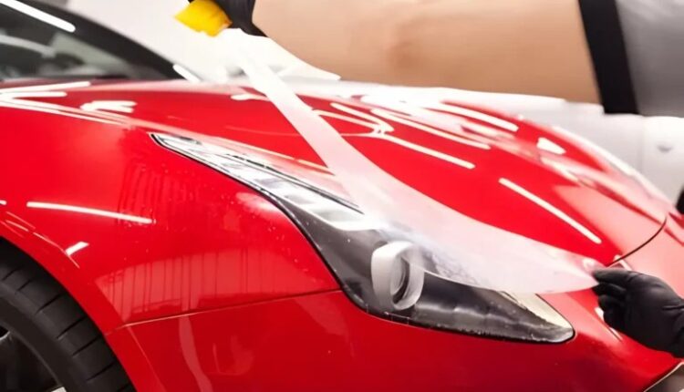 Ceramic coating UAE – paint protection film application on red luxury car under Dubai sunlight.