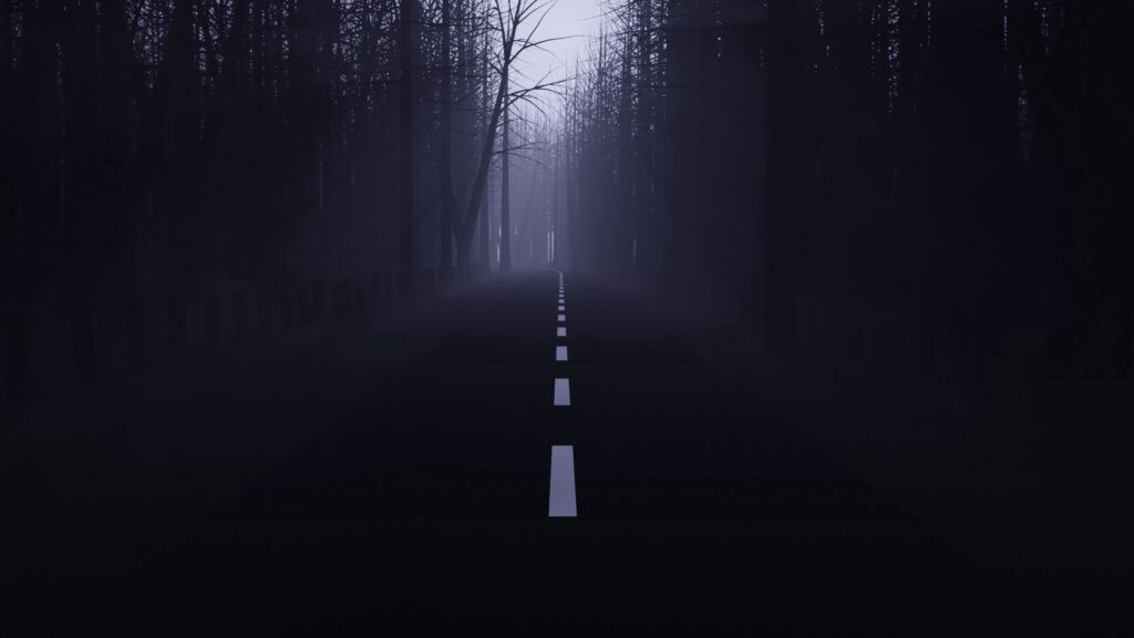 Foggy road in a dark forest, perfect for a spooky Halloween night drive.