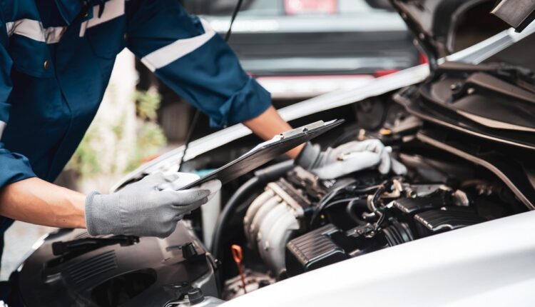 Mechanic checking Toyota Land Cruiser engine during maintenance inspection