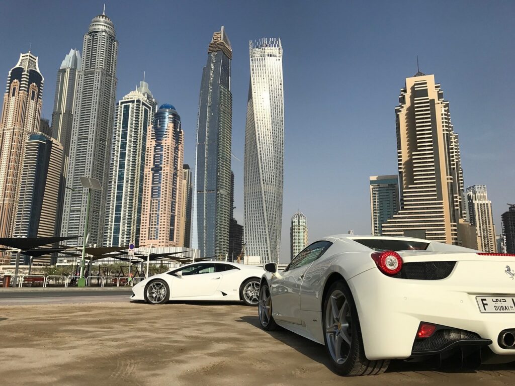 New cars parked against Dubai's iconic skyline, symbolizing the choice for first-time buyers in the UAE between new and used vehicles.