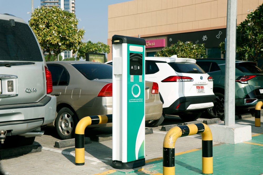 Public parking meter in Dubai, with a variety of parked cars, illustrating the parking system.