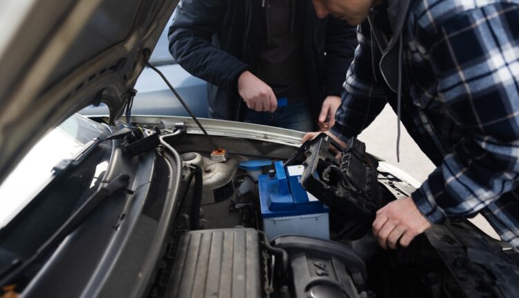 Close-up of a hybrid car dashboard showing a red battery overheating warning light and high temperature gauge.