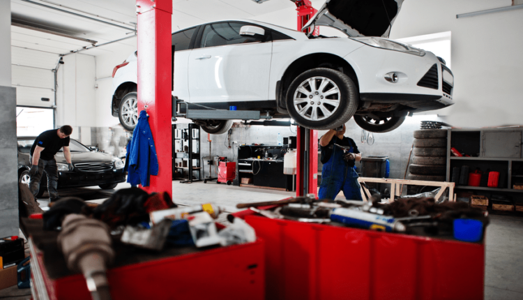 Routine car maintenance in UAE garage with vehicle lifted for inspection