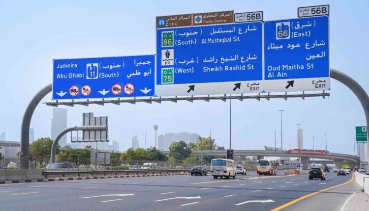 Dubai delivery rider fast lane rules shown on a multi-lane Dubai highway with overhead road signs and lane restrictions for motorcycles.