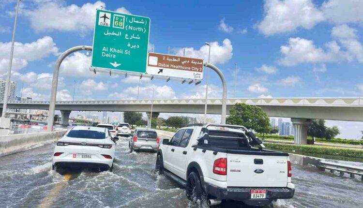 Vehicles drive through floodwater on a UAE road during heavy rain, highlighting the risks drivers face when a car stalls in deep water| Arabwheels.ae