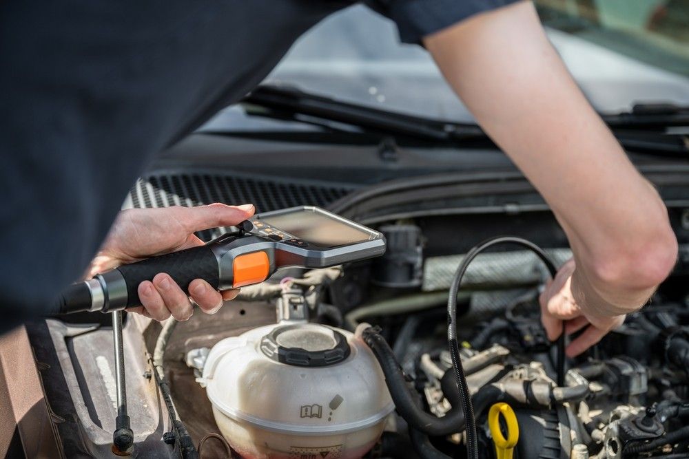 Technician using diagnostic scanner during used car pre-purchase inspection in UAE| Arabwheels.ae