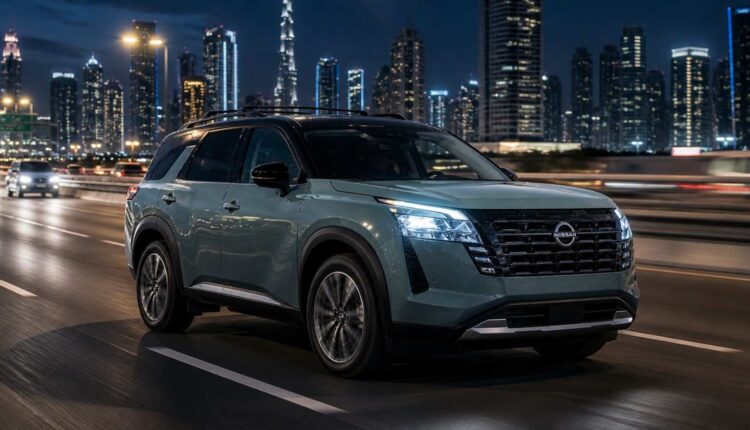 Nissan Pathfinder in UAE driving at night through a modern city skyline, showcasing a stylish and spacious family SUV on the highway