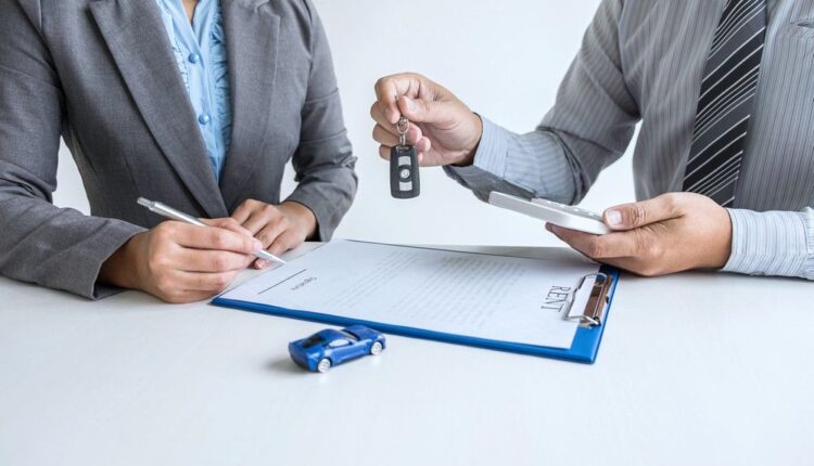 Selling a Car in Abu Dhabi with car keys being handed over during vehicle sale paperwork and ownership transfer.|Arabwheels.ae