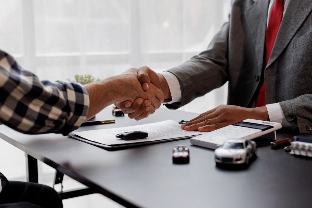 Buyer finalizing car loan documents with dealer in UAE| Arabwheels.ae