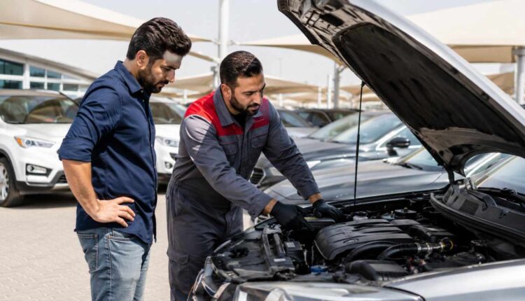 A buyer and mechanic inspect a used car with the bonnet open at a UAE dealership to choose the right used car in UAE.