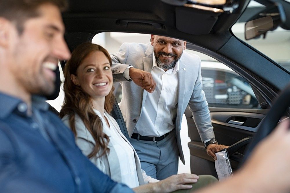 UAE car dealer explaining features to buyers during a used car test drive discussion.|Arab3wheels.ae