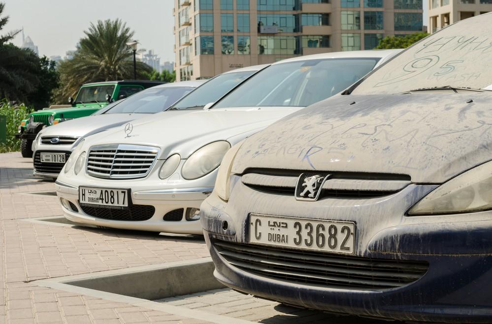 Dust-covered used cars parked in Dubai, highlighting UAE heat, dust, and the need for proper GCC-spec vehicle inspection.|Arabwheels.ae