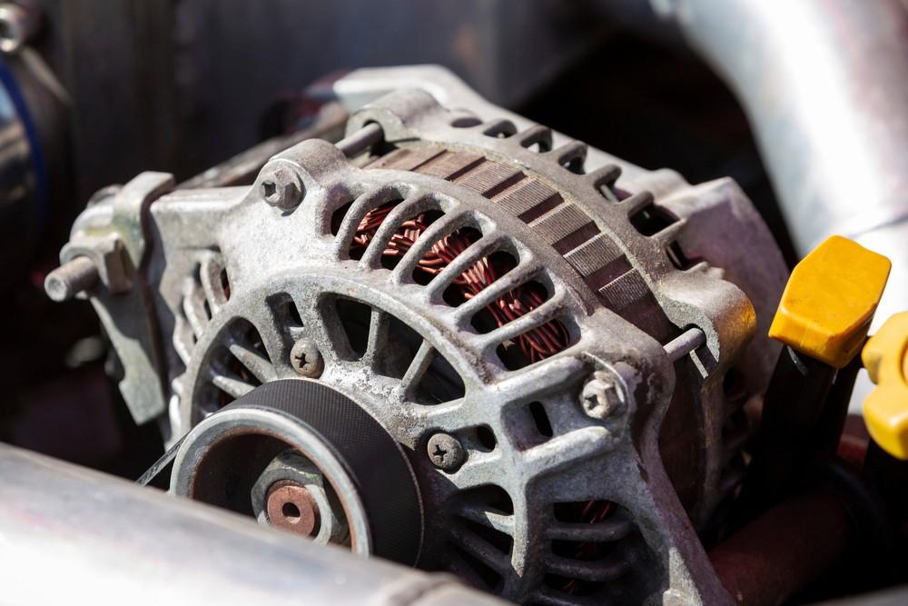Car alternator inside engine bay showing charging system problem|arabwheels.ae