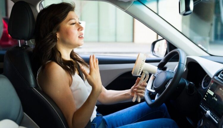 Woman feeling hot inside a car, highlighting the need for car AC diagnosis before summer UAE.