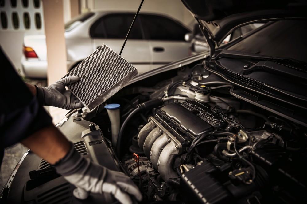 Mechanic checking a car air filter during a pre-summer vehicle inspection.|Arabwheels.ae