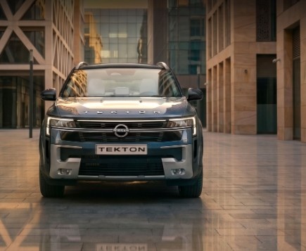 Front view of a silver Force Tekton SUV parked in a modern architectural courtyard, illuminated by warm golden light.|Arabwheels.ae