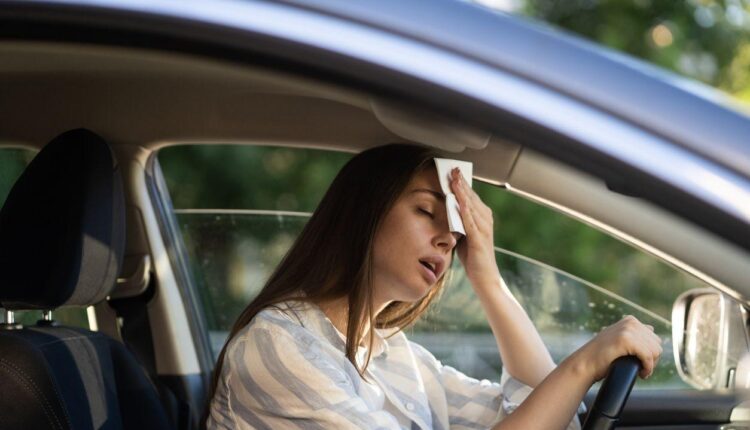 Driver feeling extreme heat inside a parked car during summer|Arabwheels.ae