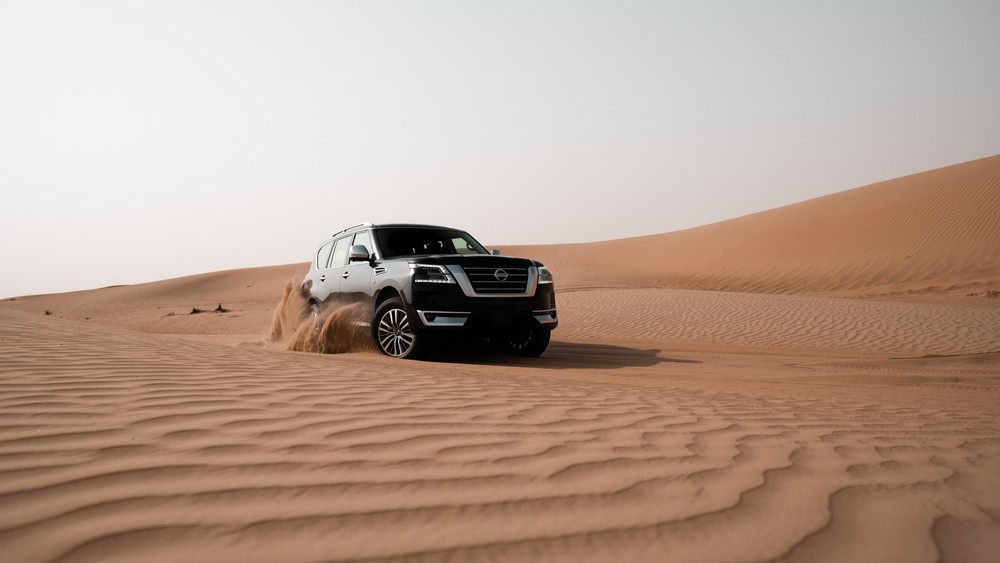 نيسان باترول تقود عبر الكثبان الرملية الصحراوية في الإمارات.|عرب ويلز