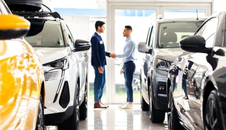 Car buyer speaking with a salesperson in a modern UAE showroom.|Arabwheels.ae