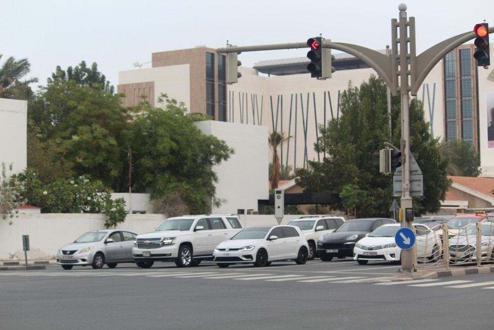 Cars waiting at a red traffic light at a busy Dubai junction.|Arabwheels.ae