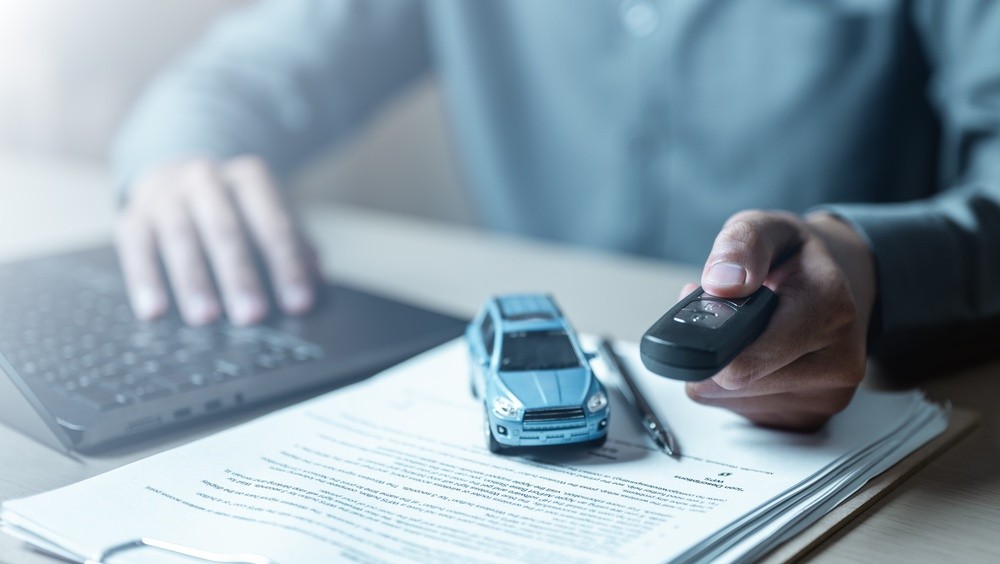 Car keys and purchase documents representing how buyers compare finance and ownership costs during the UAE new-car price war.|Arabwheels.ae